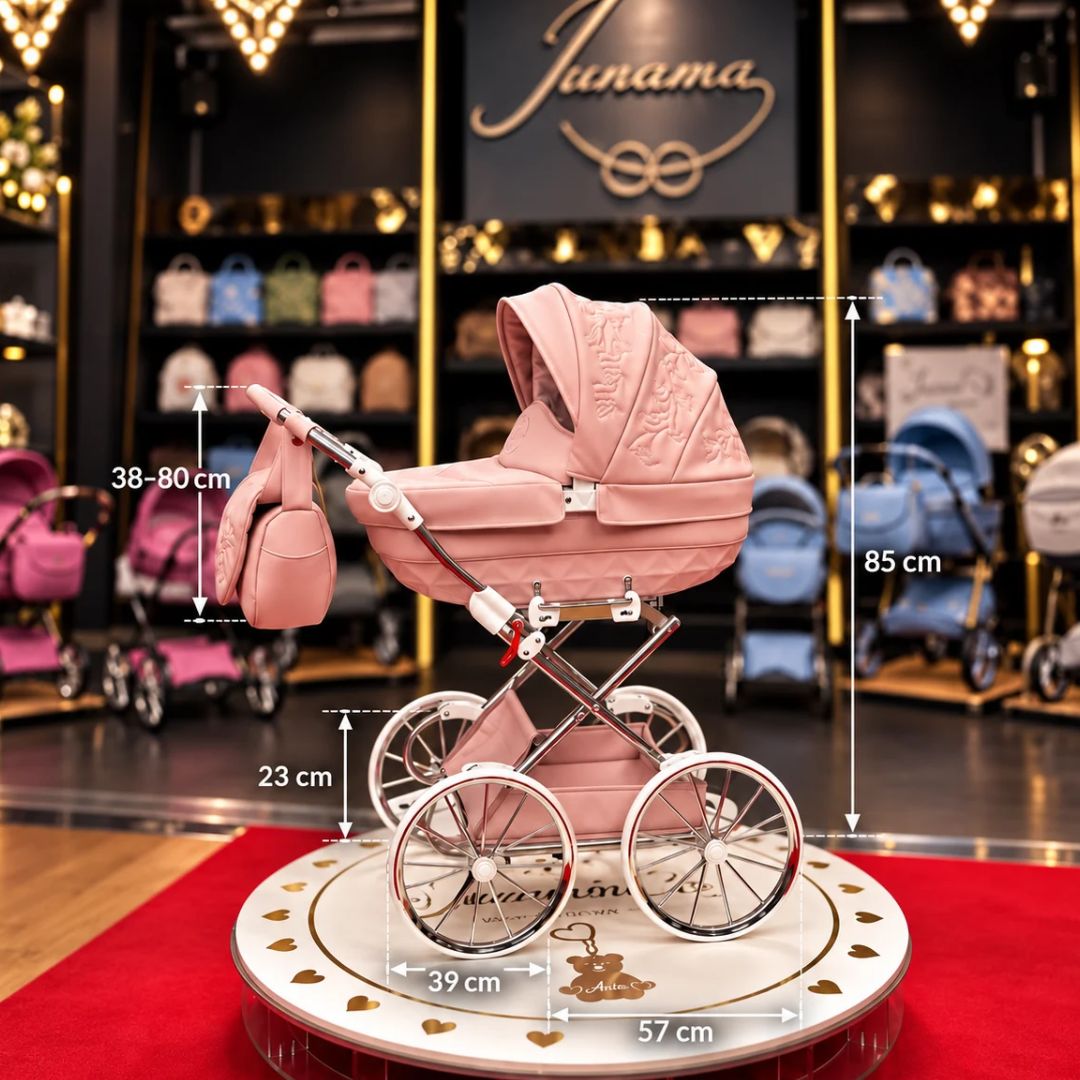 Carrito de muñeca Enzo Mini rosa con capota bordada, chasis cromado y ruedas grandes de estilo clásico.